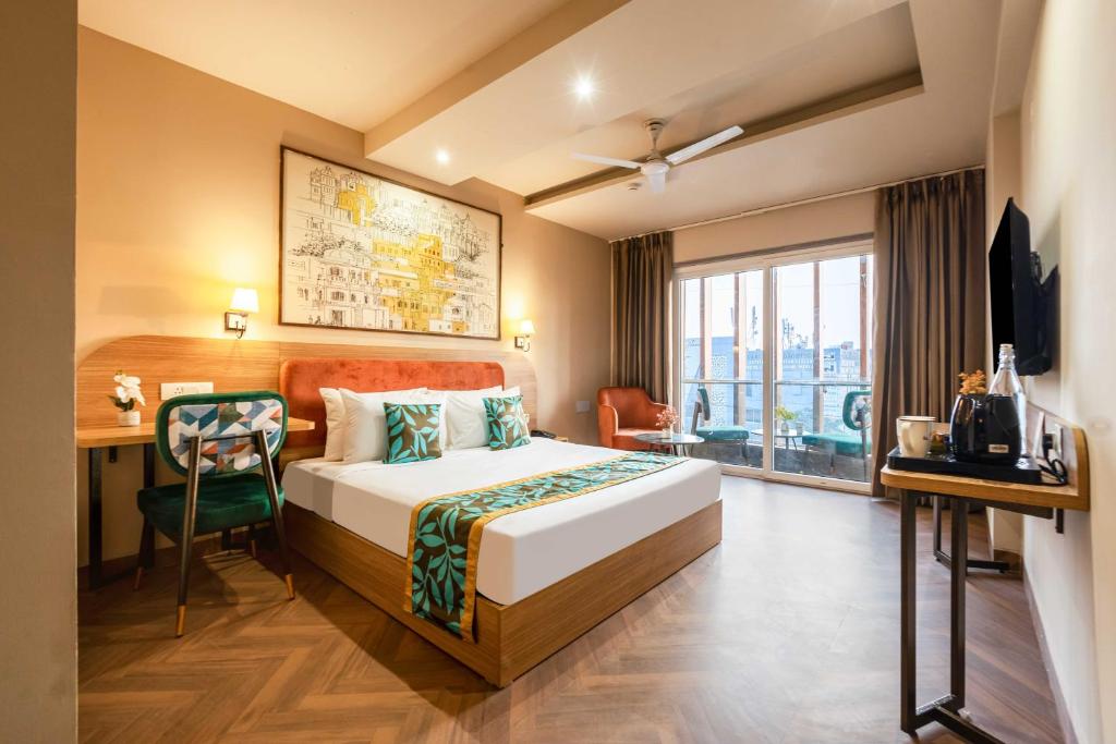 a hotel room with a bed and a desk and a television at Saltstayz Select- Medicity Near Medanta Hospital in Gurgaon