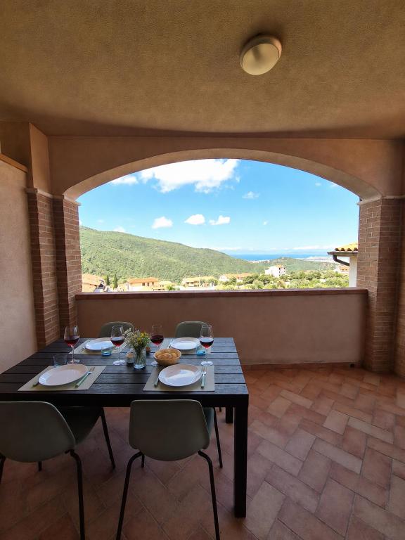 ein Esszimmer mit Tisch und Stühlen und einem großen Fenster in der Unterkunft Mare Maremma in Scarlino
