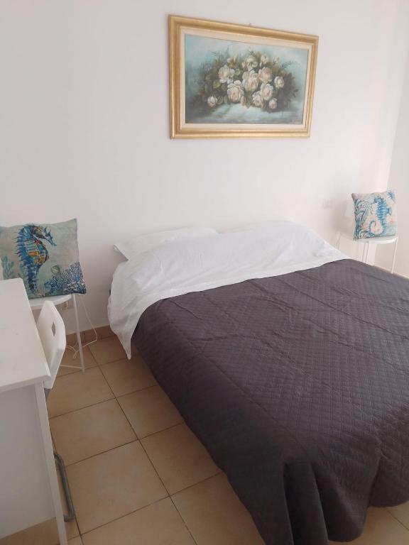 a bedroom with a bed and a painting on the wall at Ippocampo in Giardini Naxos