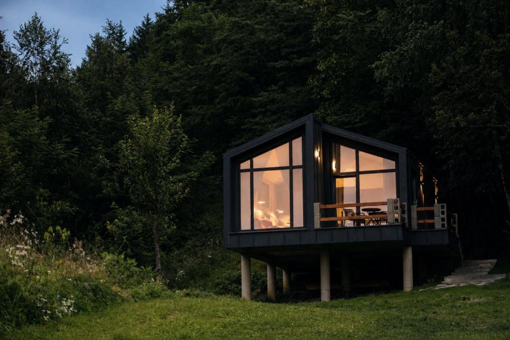 a black house on the grass in a field at RAC by Zodiac Resort in Ceraşul