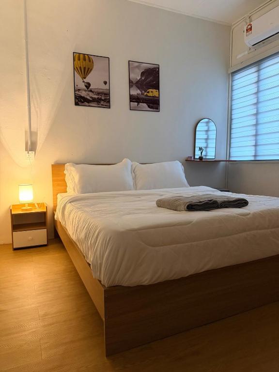 a bedroom with a large white bed in a room at Kuantan Tiny Homestay in Kuantan