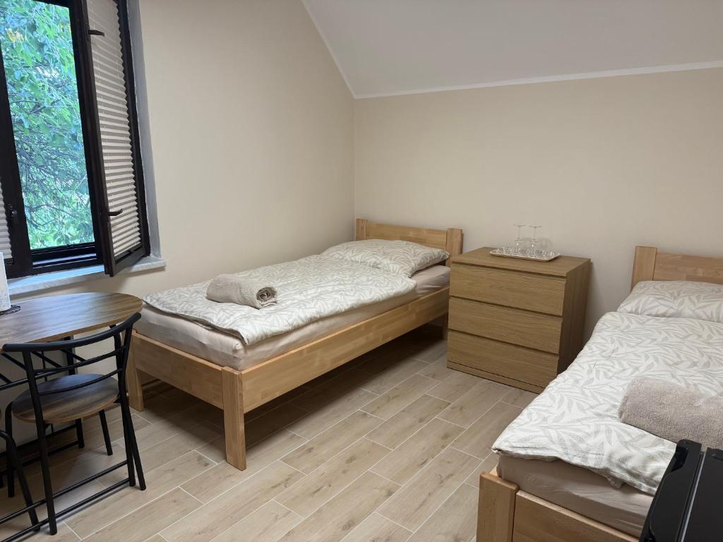 a bedroom with two beds and a desk and a table at Ubytování U Dědečka in Lomnice nad Lužnicí