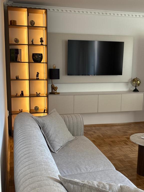 a living room with a couch and a flat screen tv at BL Urban Stay in Starčevica