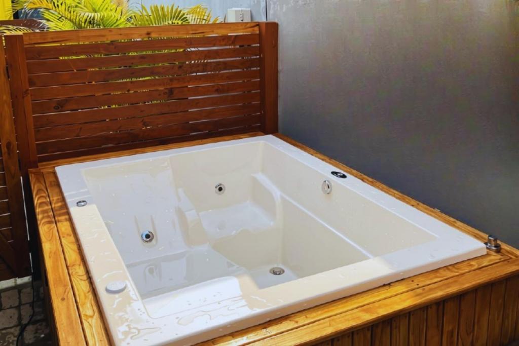 a large white bath tub sitting in a room at SPA-AC-BBQ-Casa Container-Cozinha Completa in Florianópolis