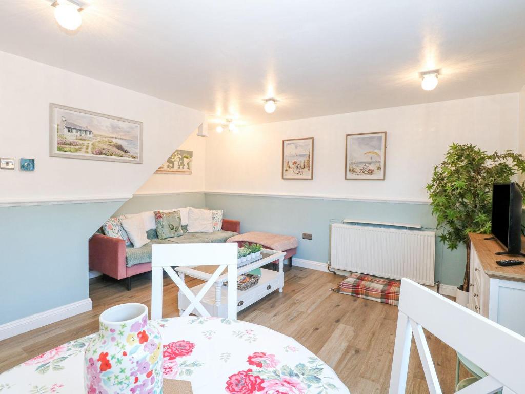 a living room with a couch and a table at Hideaway Cottage in Hunstanton