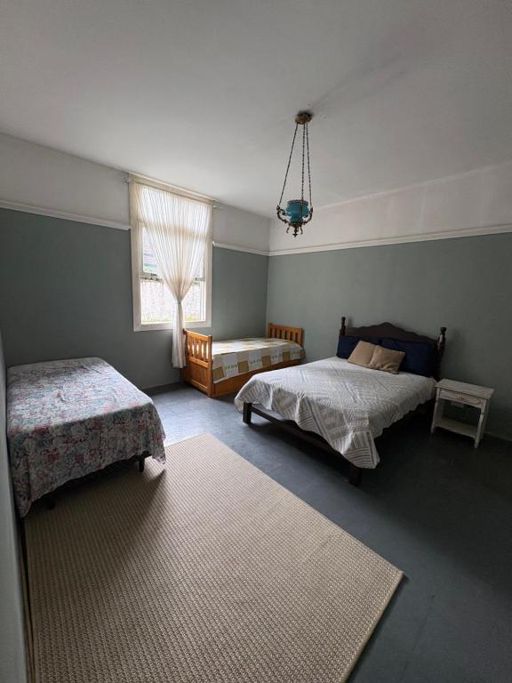 a bedroom with two beds and a window at Villa Aruanda in Petrópolis