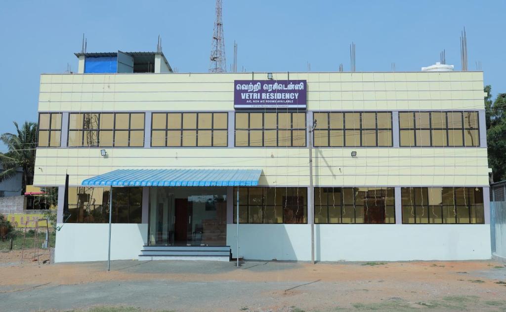 a white building with a sign in front of it at Vetri Residency in Agastīswaram