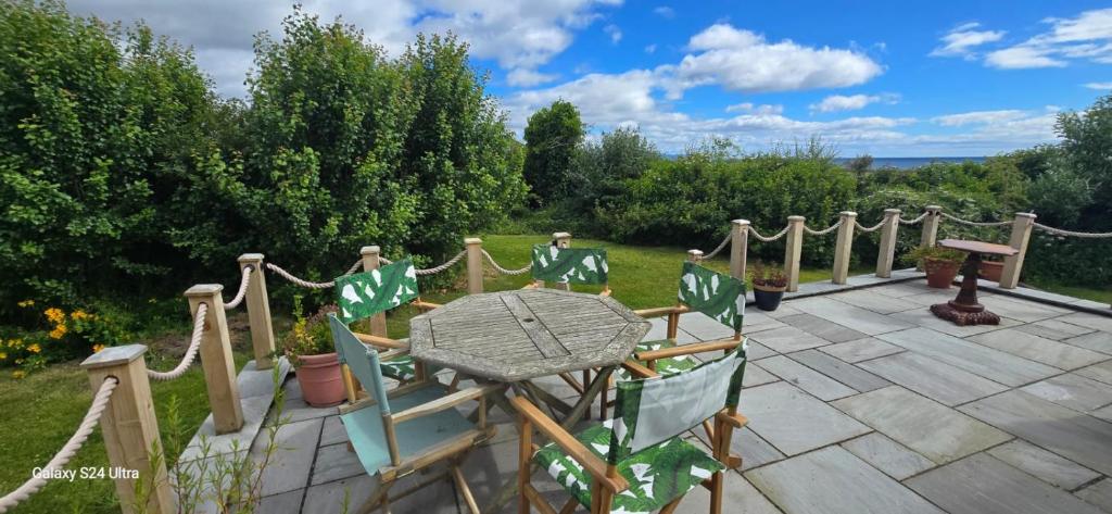 a patio with chairs and a table in a garden at Beautiful Highland Sanctuary in Embo