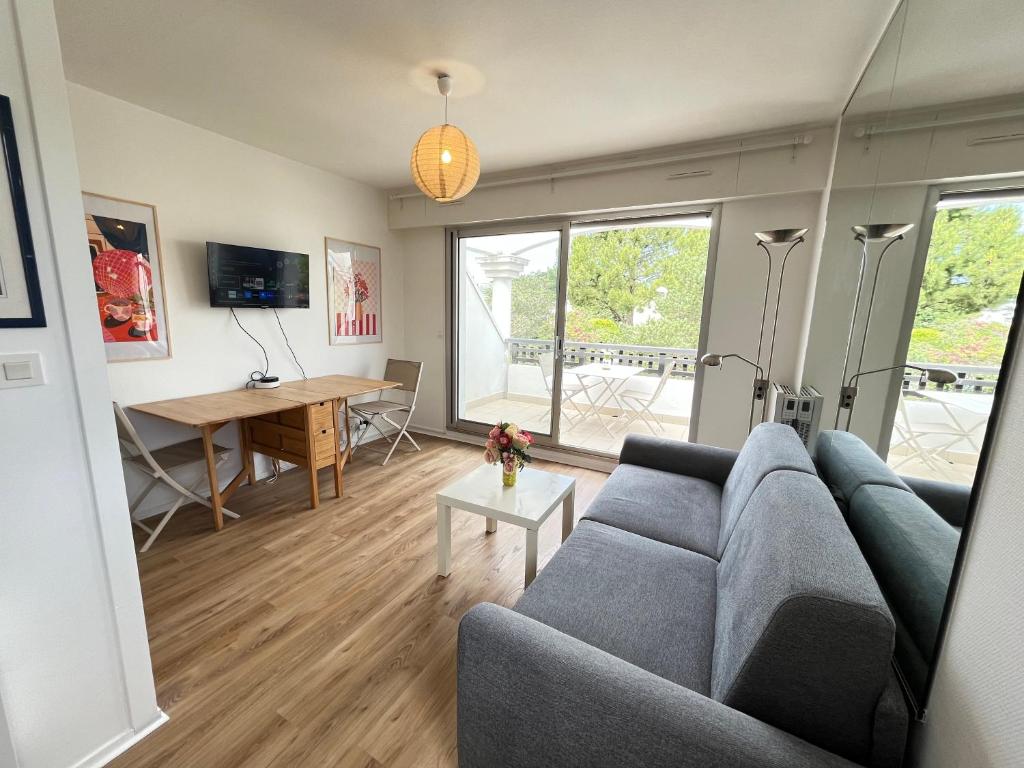 a living room with a couch and a table at Le Cocon Baulois in La Baule
