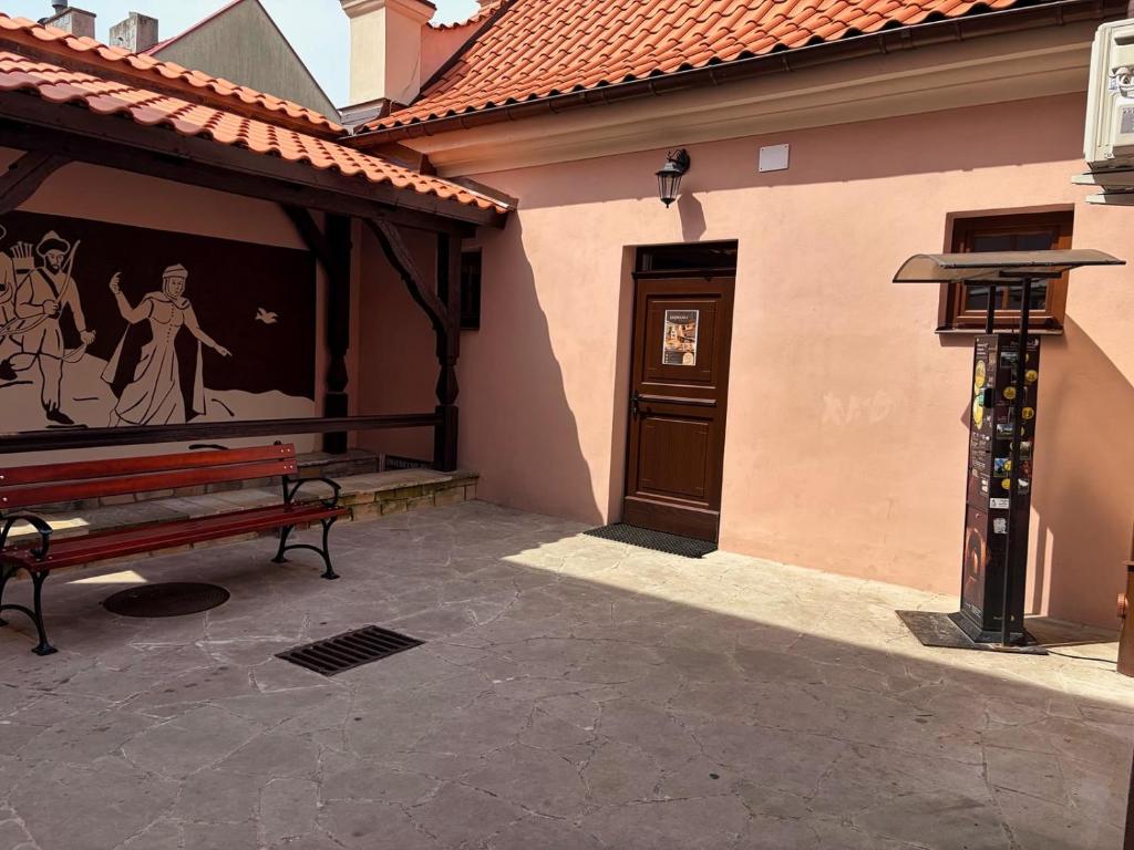 a bench sitting outside of a building with a door at Krępianka in Sandomierz