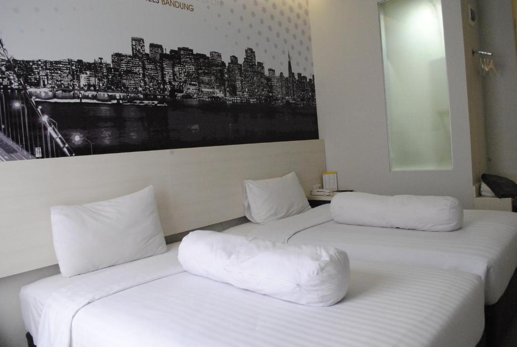 2 lits blancs dans une chambre avec une photo sur le mur dans l'établissement Vio Westhoff, à Bandung