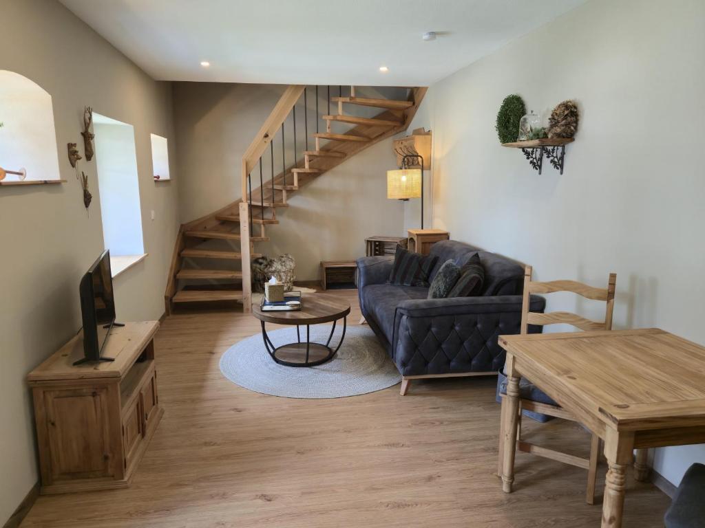 a living room with a blue couch and a staircase at Ferienhaus Frida in Kleinich