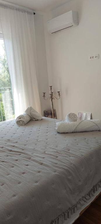 a large bed in a white room with a window at Apartman Ika 2 in Kruševo