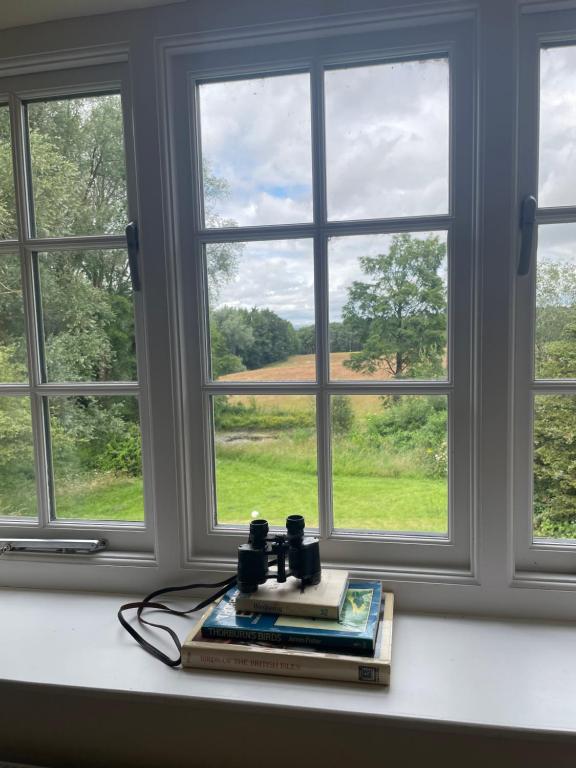 a book sitting on a table in front of a window at Thorn Tree Garth in Coulton