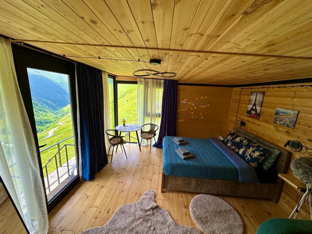 a bedroom with a bed and a balcony with a table at Hiking in Jut'a