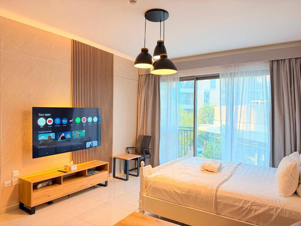 a bedroom with a bed and a flat screen tv at Aesthetic Kings Studio at Uptown Al Zahia Sharjah in Sharjah