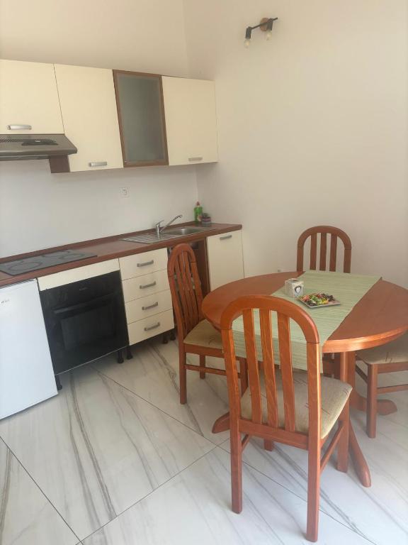 a kitchen with a table and two chairs and a table and a sink at Tramontana apartments in Dugobabe