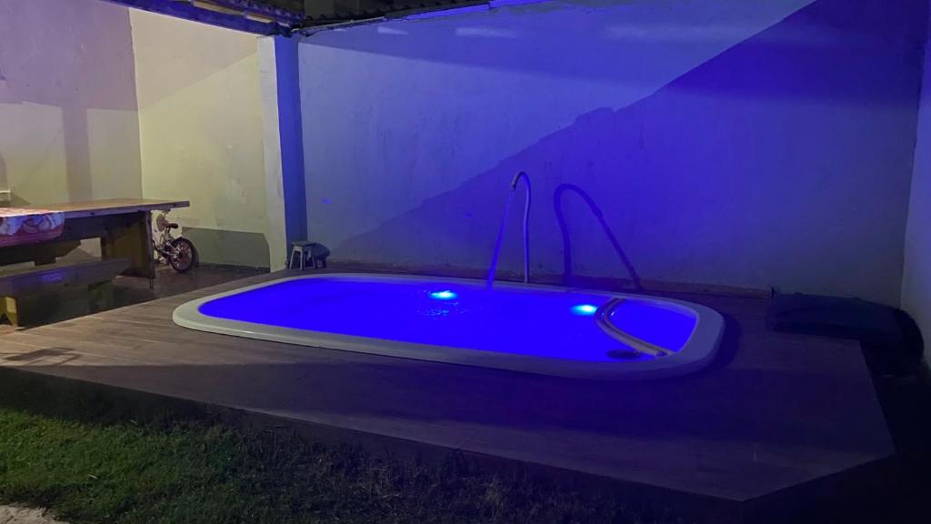 a blue bath tub in a room with a table at Casa completa com piscina 12min da praia in Porto Seguro