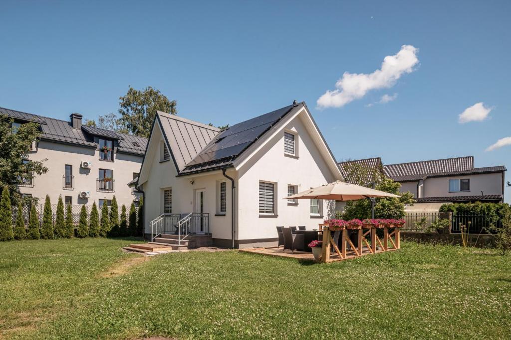 a white house with an umbrella in the yard at Leonardo Vila Centre in Palanga