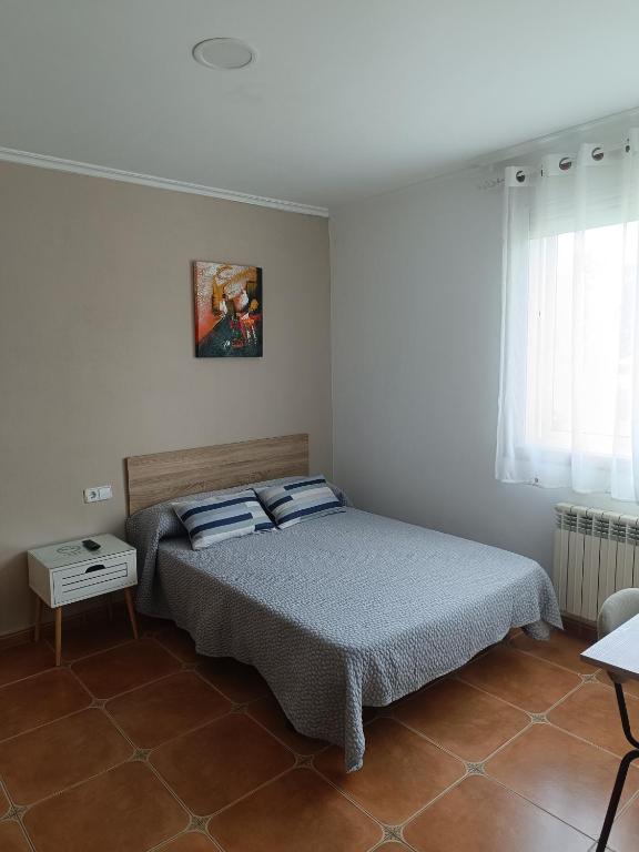 a bedroom with a bed with blue pillows on it at Casa Alonso in Narón