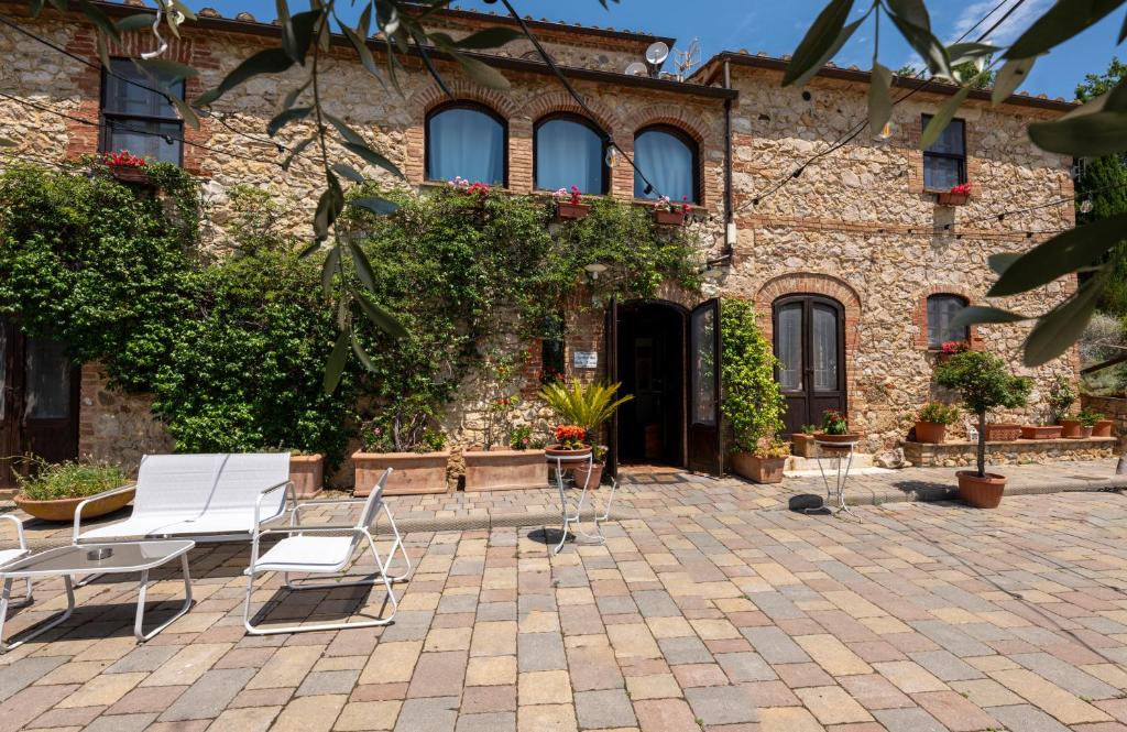 a brick building with two chairs and a table at Podere Santa Maria in Monte Antico