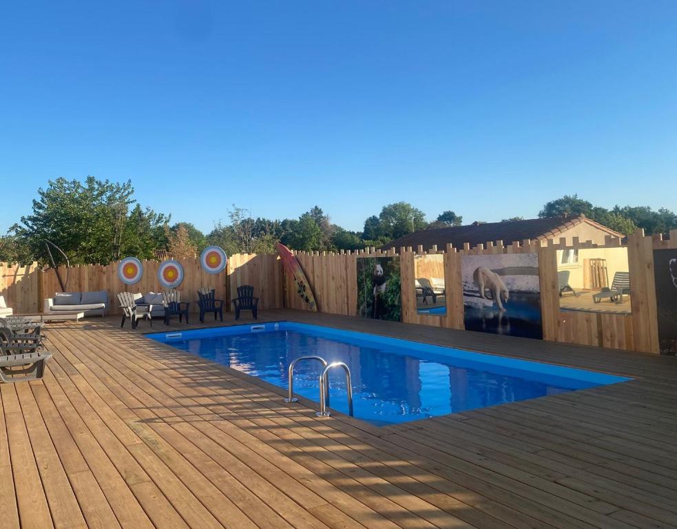 a swimming pool on a wooden deck with a fence at Olydea Le Hameau de Vouvant in Vouvant