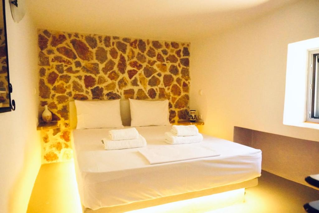 a bedroom with a white bed with a giraffe wall at Case De Drymona 1 in Kythira