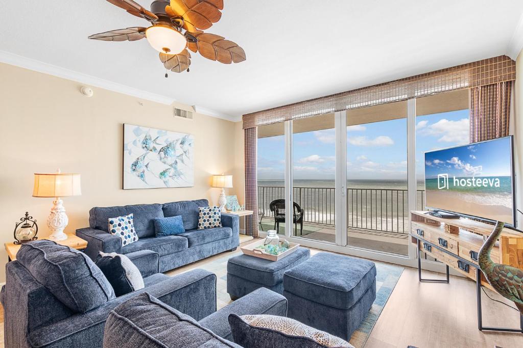 a living room with blue couches and a tv at San Carlos 1503 in Gulf Shores