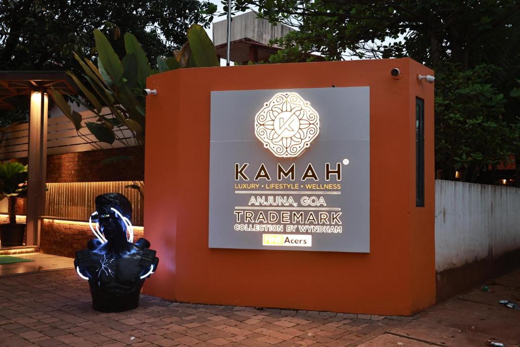 a sign with a statue sitting in front of it at Kamah, Goa in Anjuna