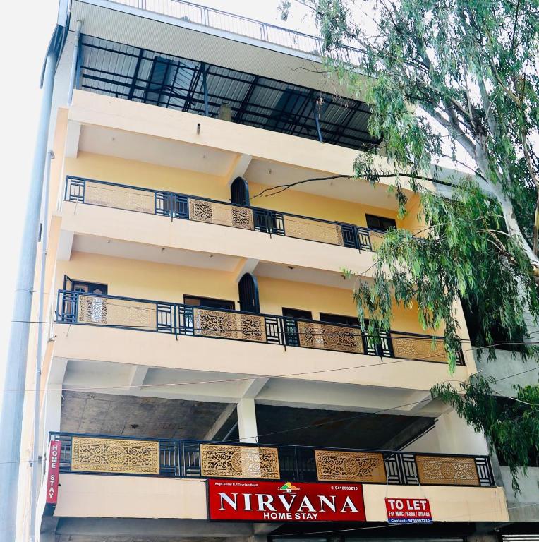an apartment building with balconies and a sign on it at Nirvana Homestay in Chamba