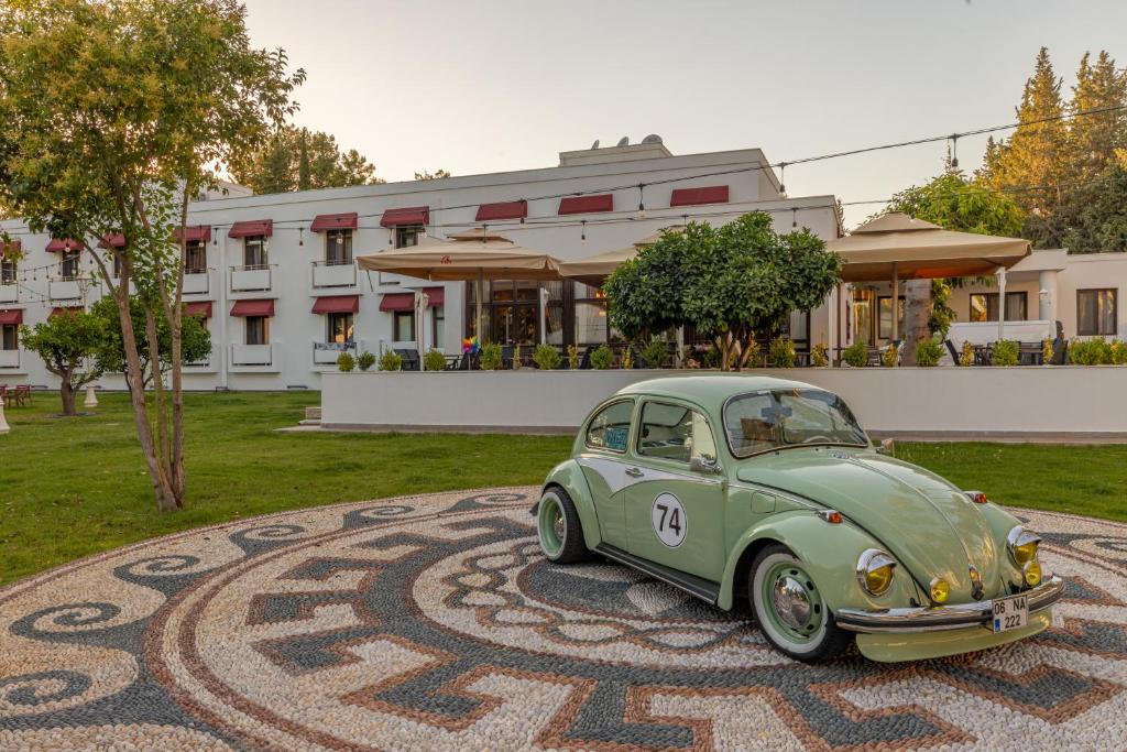 Ein grünes Auto, das auf einem Teppich geparkt ist. in der Unterkunft 74 Otel in Antalya