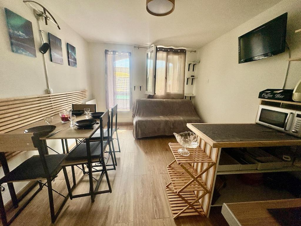 a living room with a table and a couch at Refuge 1000, studio cosy in Mijoux