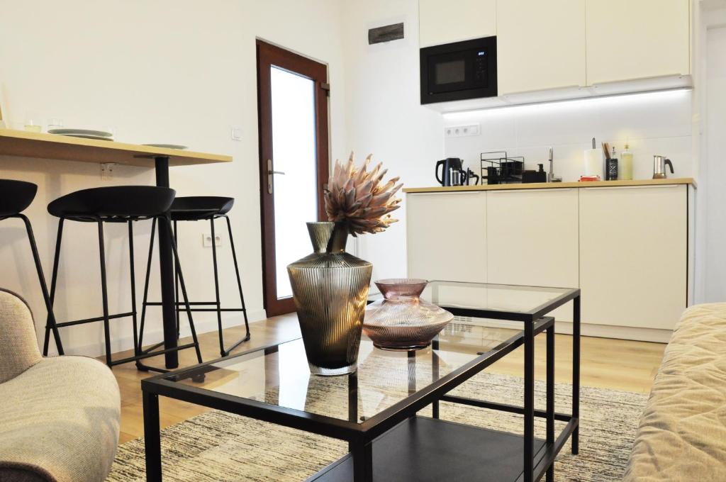 a living room with a glass table with a vase on it at Centrum Comfort Apartment in Rimavská Sobota