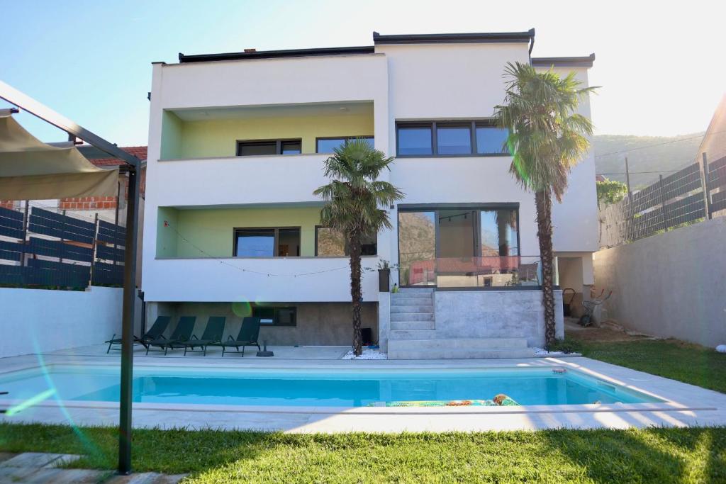a house with a swimming pool in front of a house at Villa Vincek in Mostar