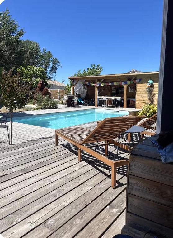 a swimming pool with benches and a table next to it at Maison Route de l'Océan in Sainte-Hélène