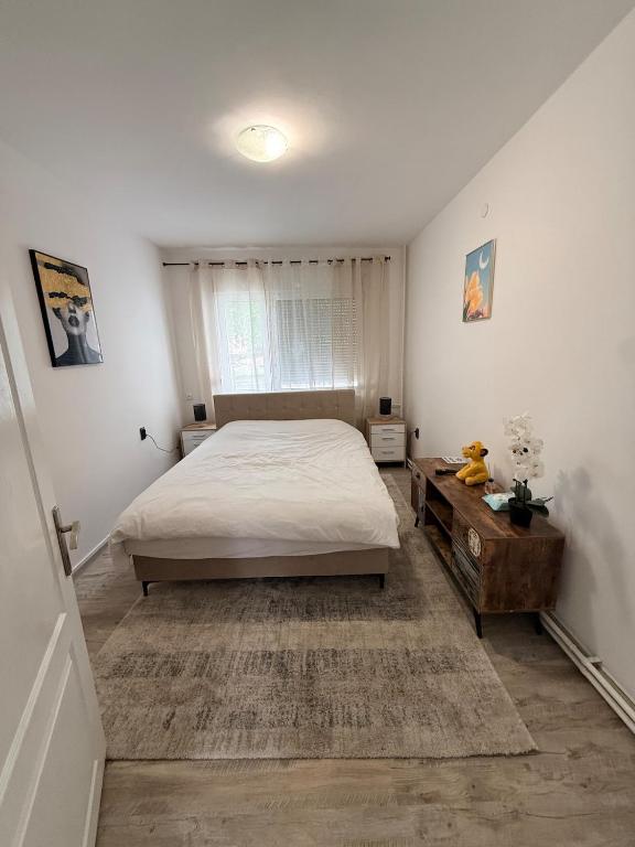 a bedroom with a bed and a wooden table at Modern Cozy Apartment Lola in Doboj