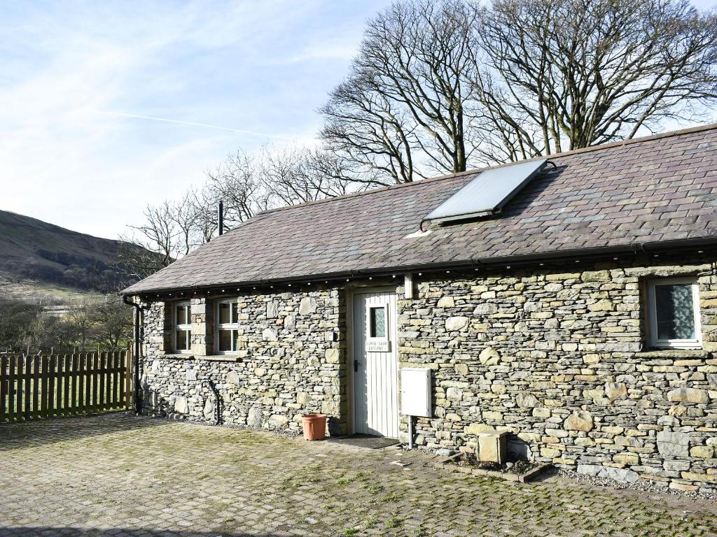 a stone building with a roof and a door at Riverbank Cottage-Uk42229 in Low Borrowbridge