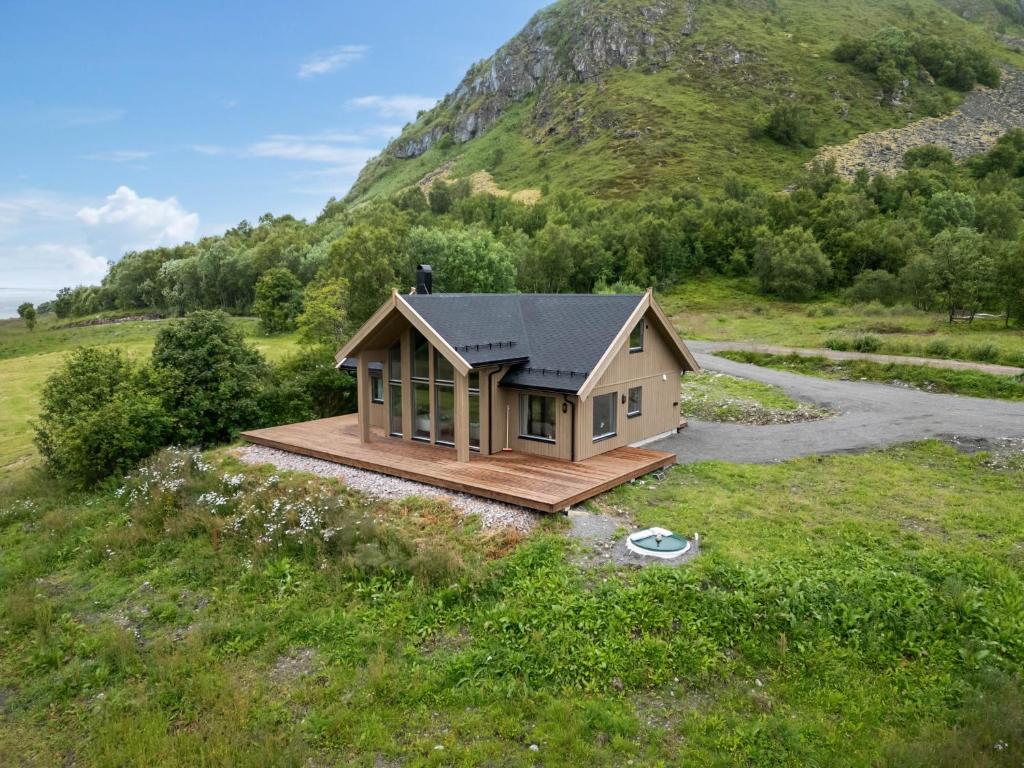 a small house in a field next to a mountain at Hoven Lodge in Vik