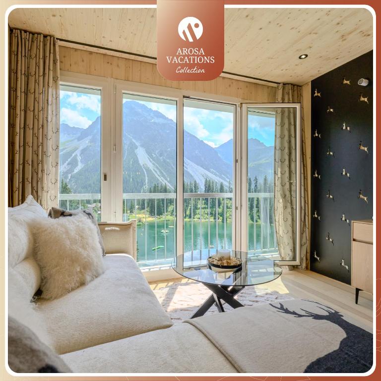 a living room with a couch and a glass table at appartamaint tscherv by Arosa Vacations, Exklusive Wohnung im Zentrum mit Blick auf den Untersee und die Berge inkl Parkplatz in Arosa