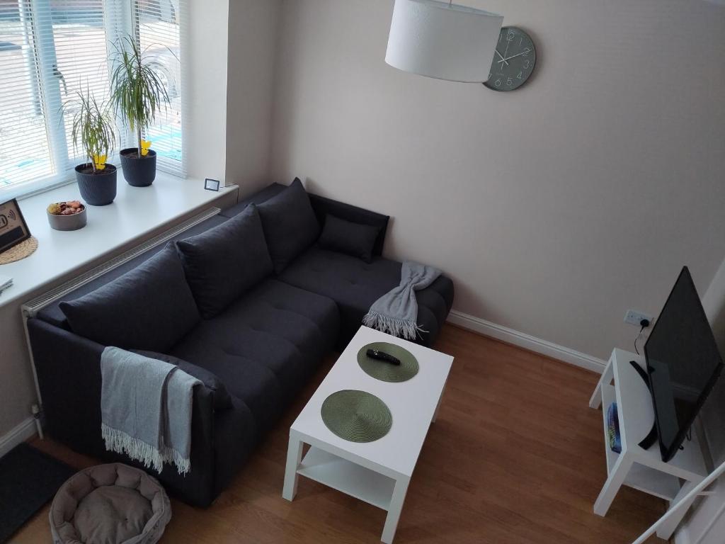 a living room with a black couch and a table at Modern 2 bedroom house, sleeps 5 guests, Free parking in Hull