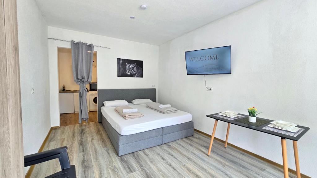 a white room with a bed and a table at Cozy Studio Apartment In The Black Forest in Villingen-Schwenningen