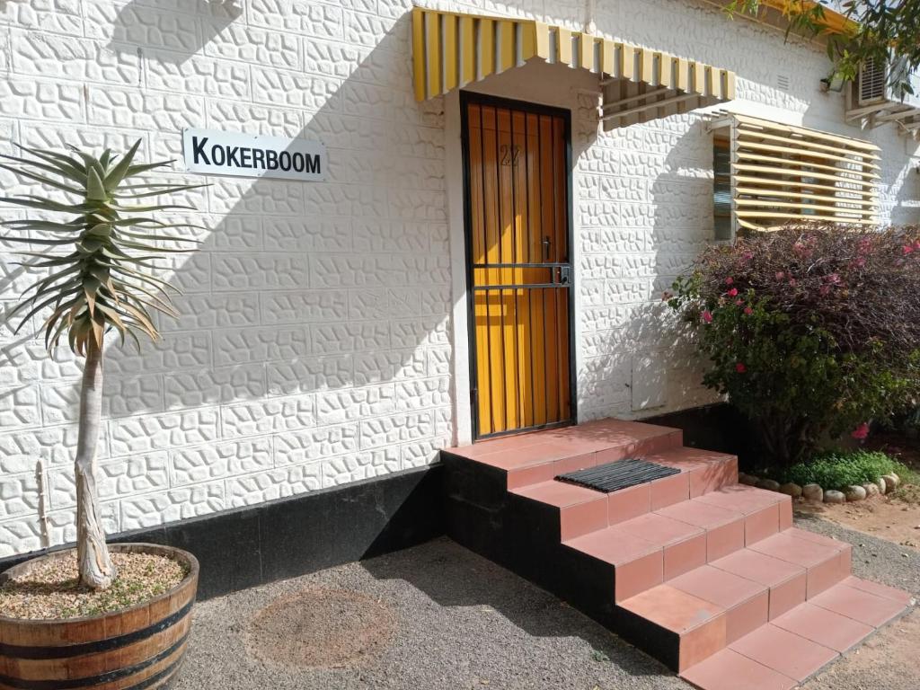 a building with a door and a plant in front of it at Springbok Lodge & Restaurant in Springbok