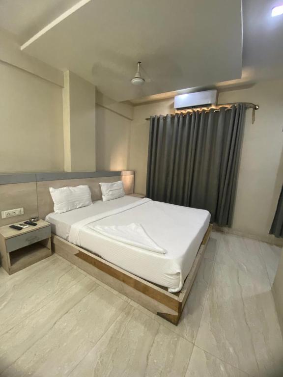 a bedroom with a large bed in a room at Hotel Bhiwandi Palace Nashik Highway Rd in Bhiwandi