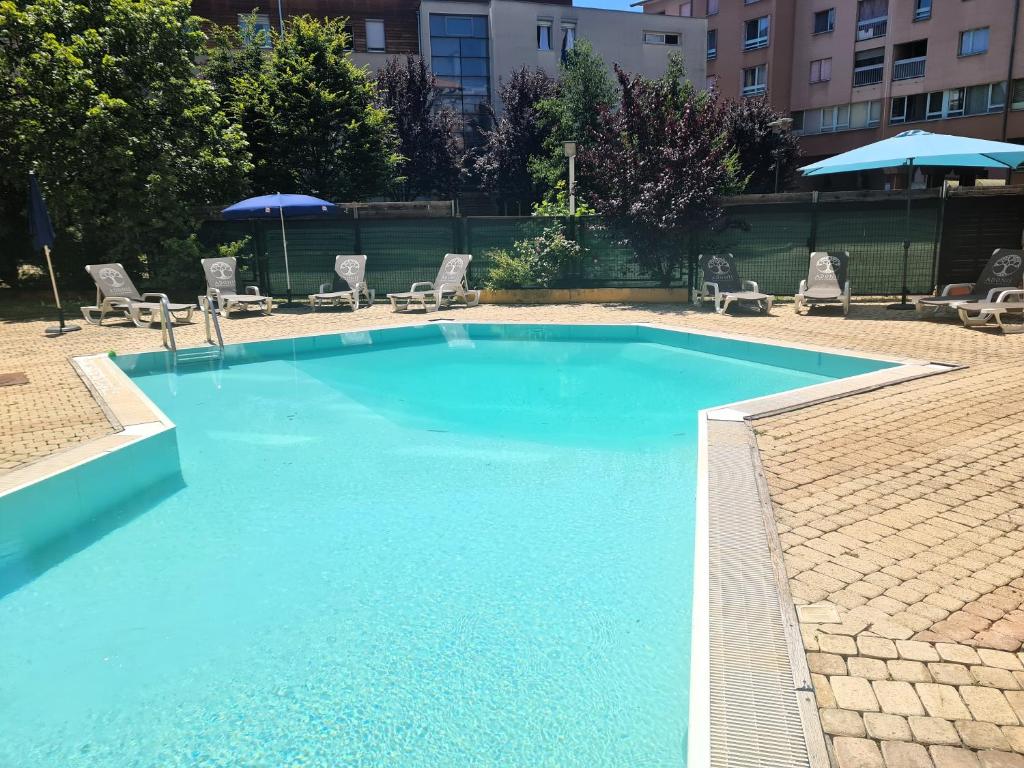 a large swimming pool with chairs and umbrellas at Adonis Gapotel in Gap