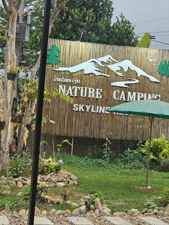 a sign for a nature camp with an umbrella at SKYLINE vangvieng Resort in Vang Vieng