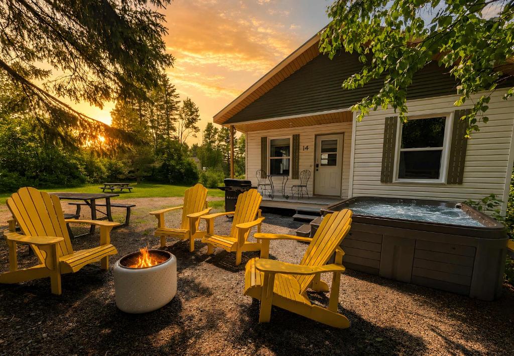 a backyard with chairs and a hot tub at Charlevoix spa bbq fire & nature in Saint-Tite-des-Caps