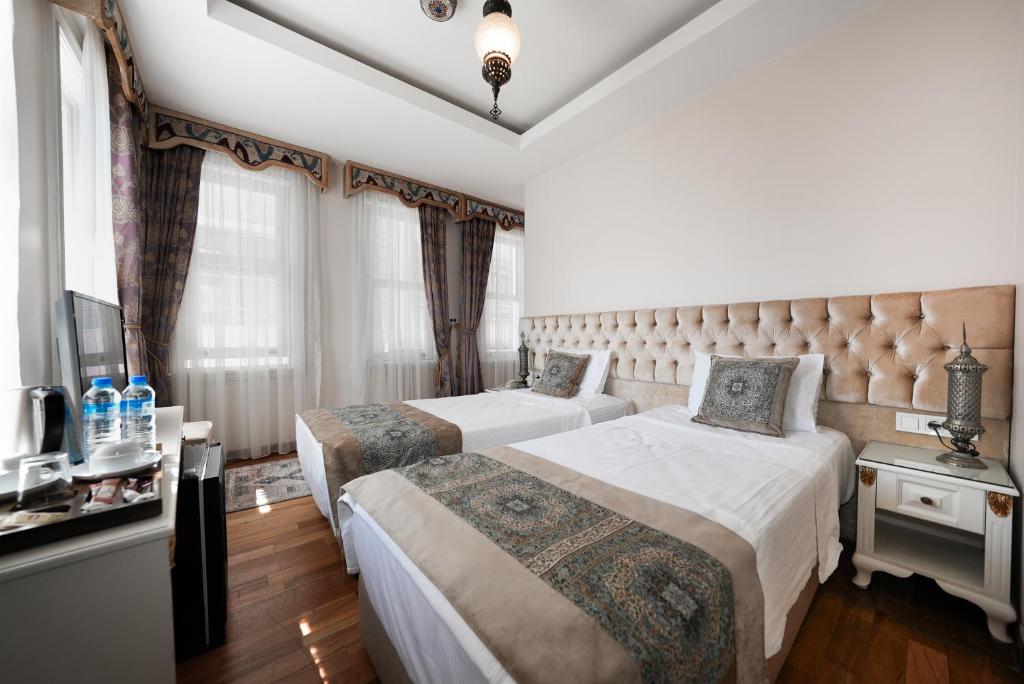 a hotel room with two beds and a tv at Ersari Hotel in Istanbul