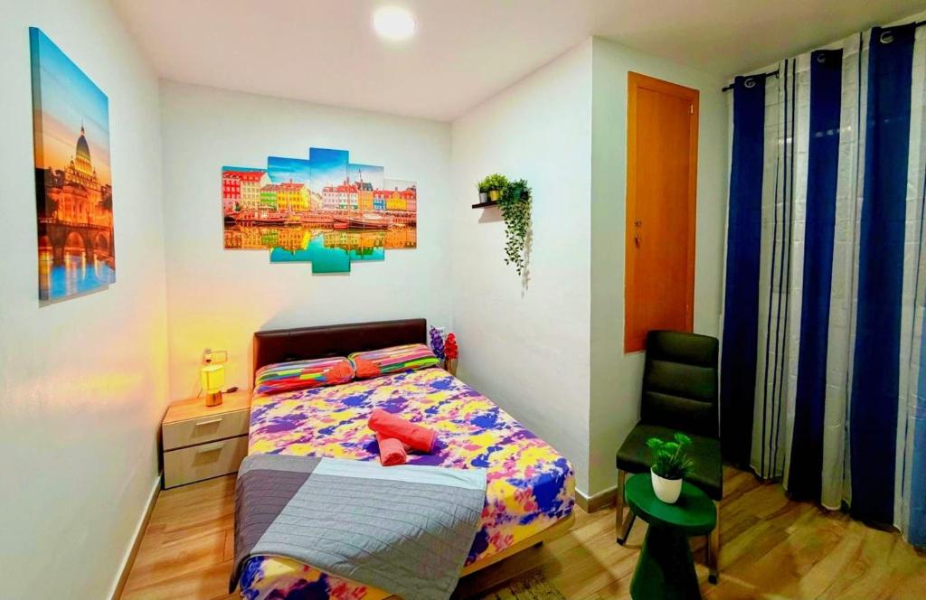 a bedroom with a bed and a chair at close to beach and 15 mints to la rambla by tren in Sant Adria de Besos
