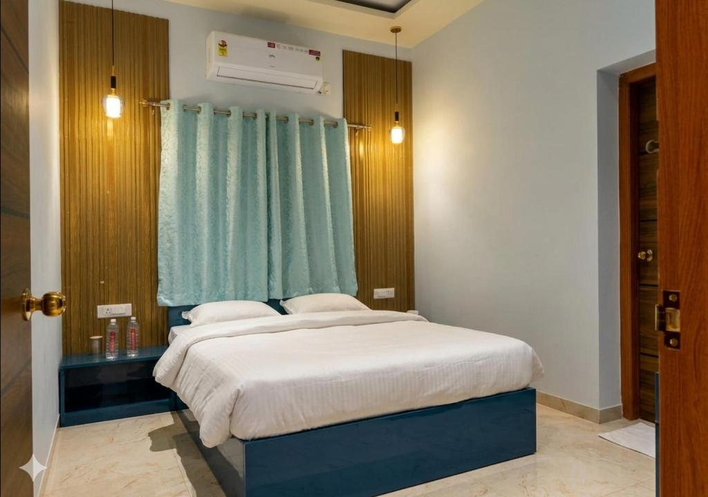 a bedroom with a bed with a blue curtain at Raj Royal Hotel in Nagpur