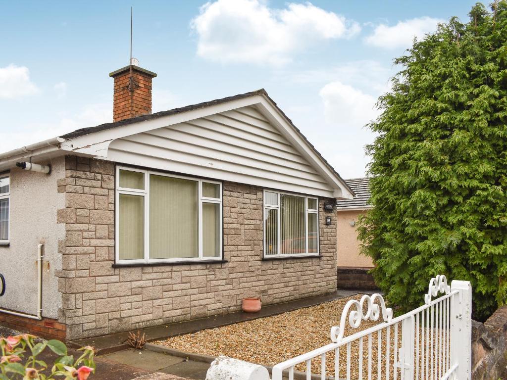 a small brick house with a white fence at Gwynfa in Rhyl